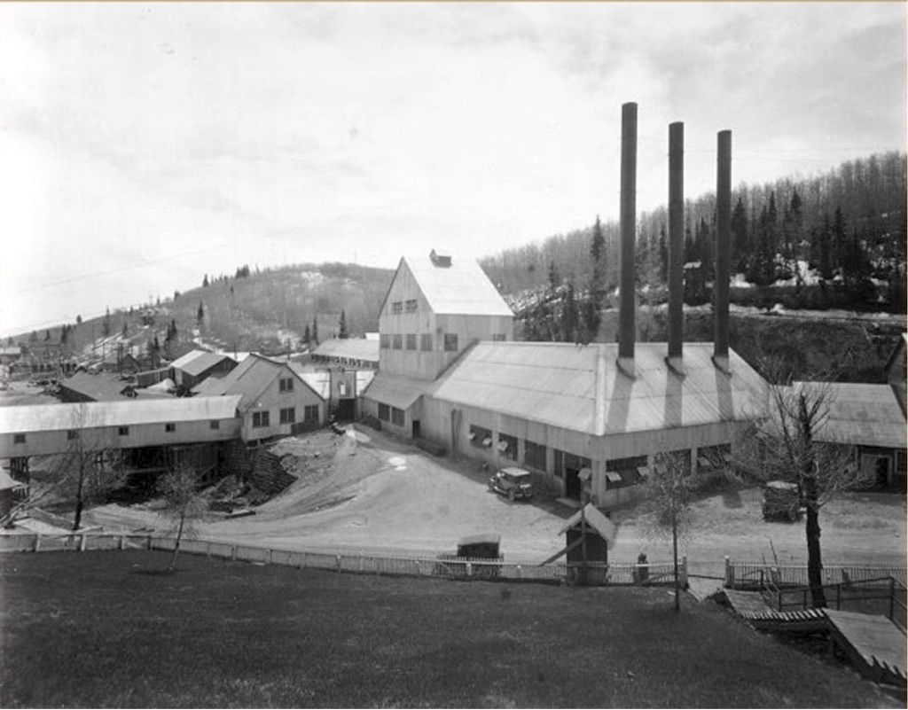 Historical Silver King Coalition mine complex in the 1920s, with three tall smokestacks rising above the headframe building