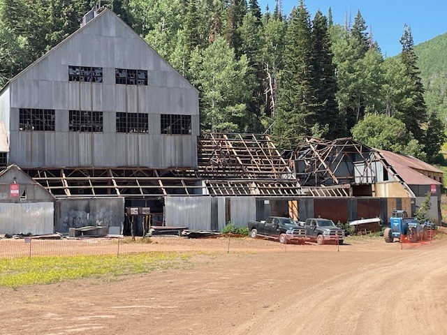 Restoration work in progress on the Silver King Mine, showing the exposed roof framing under repair